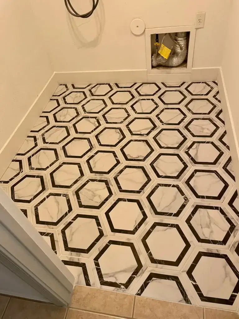 Custom geometric hexagon tile floor in white marble with black marble accents and white square inserts installed by Zona Floors in an Arizona laundry room