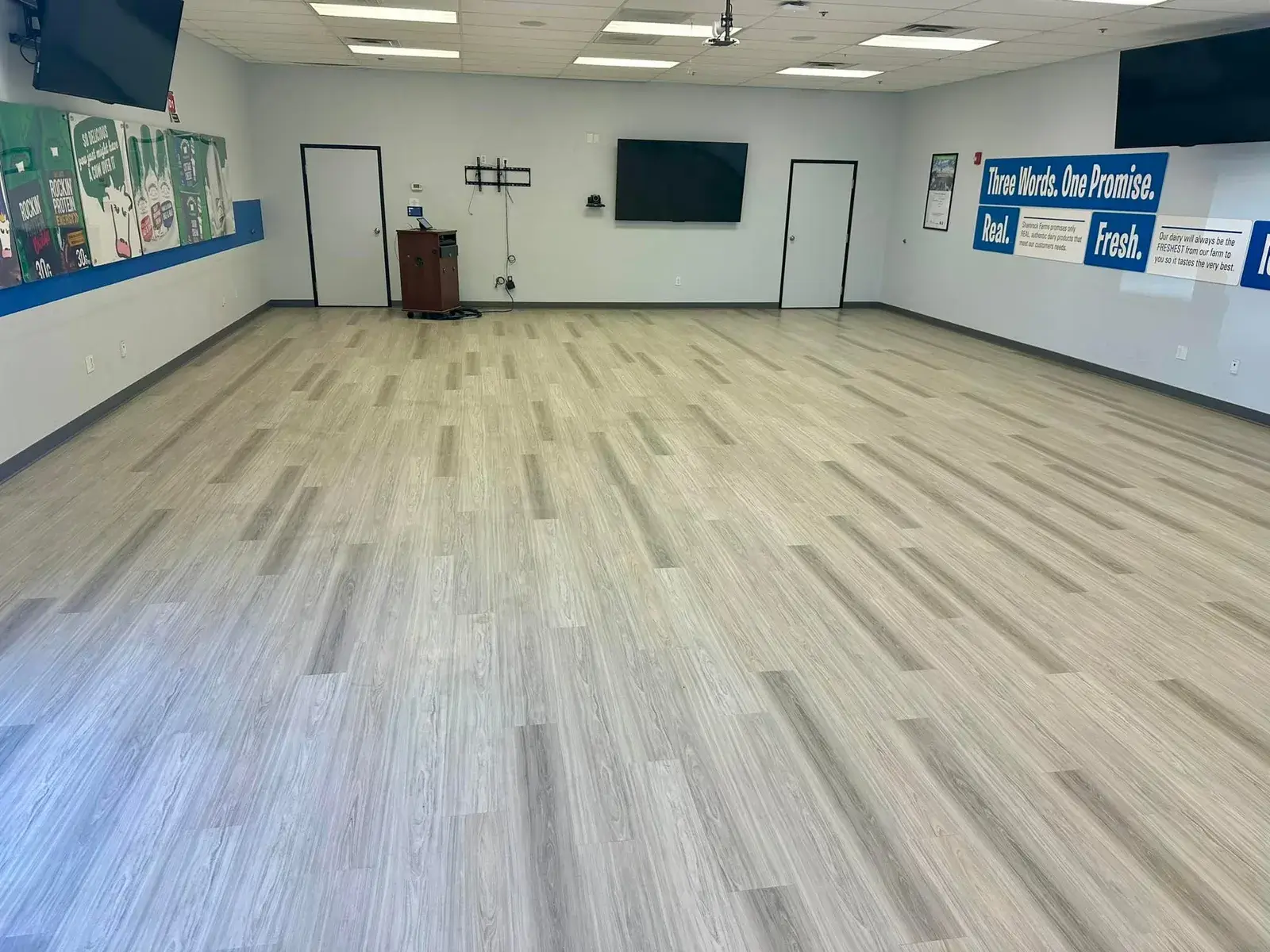 Wide open commercial-style Arizona room with light grey luxury vinyl plank flooring spanning the entire space, installed by Zona Floors