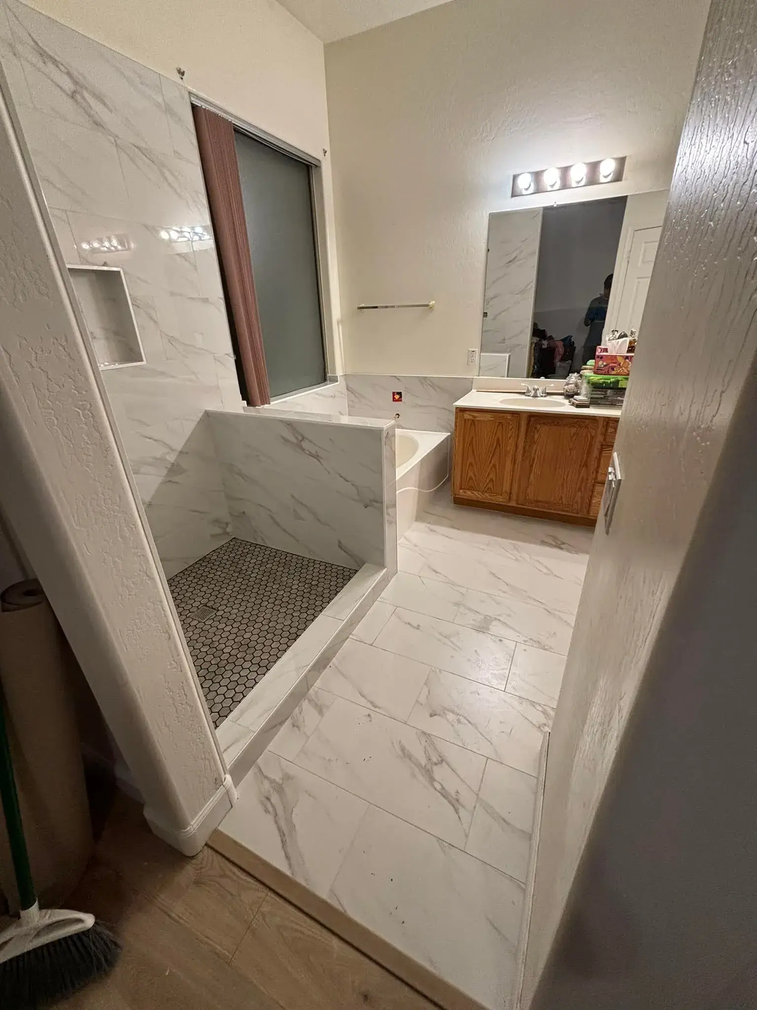 Modern white marble master bathroom remodel with walk-in shower and floating vanity by Zona Floors in Arizona